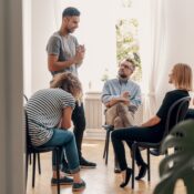 Man talking in group therapy during addiction treatment in Los Angeles.